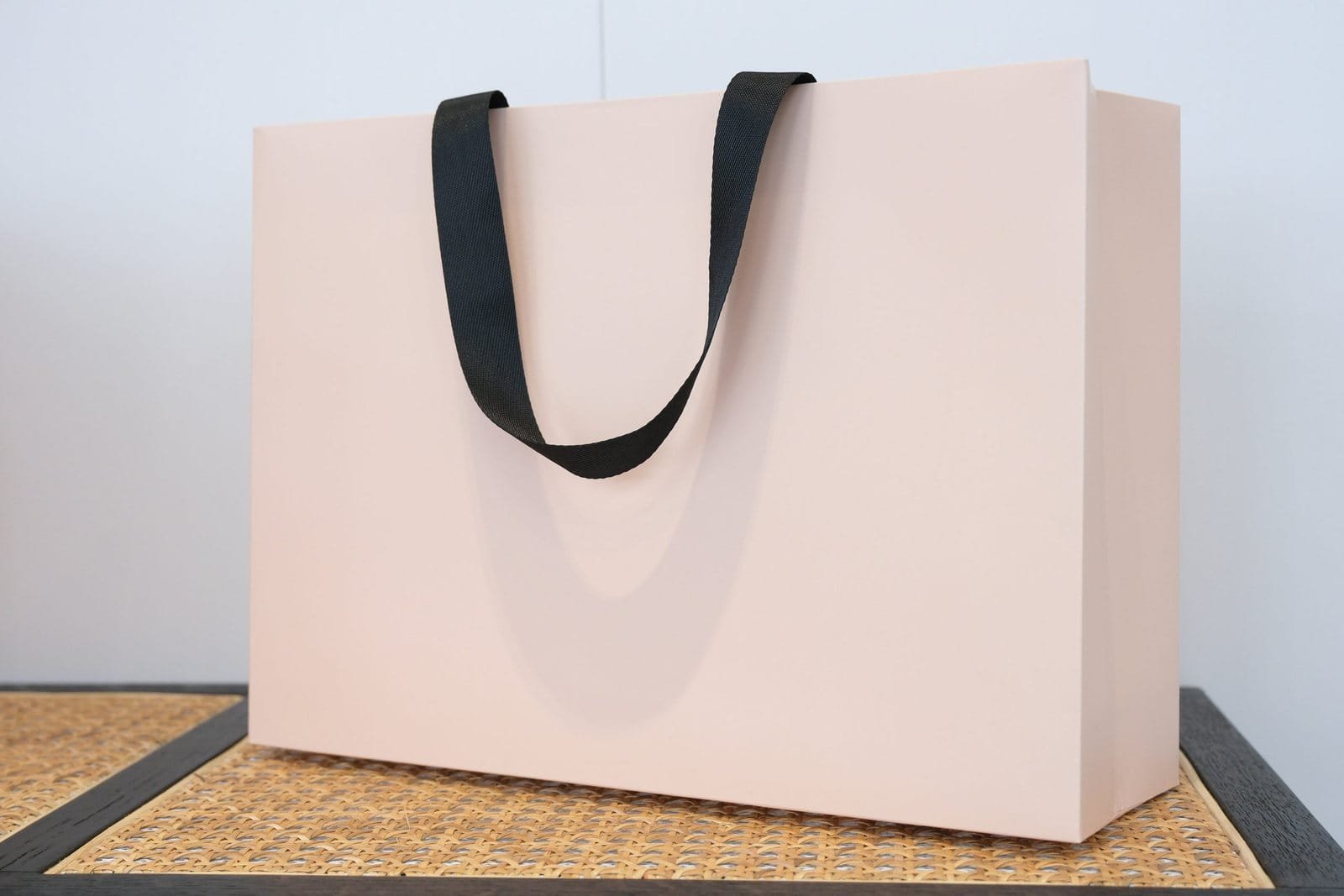 Blush pink paper bag sample with black flat ribbon handles