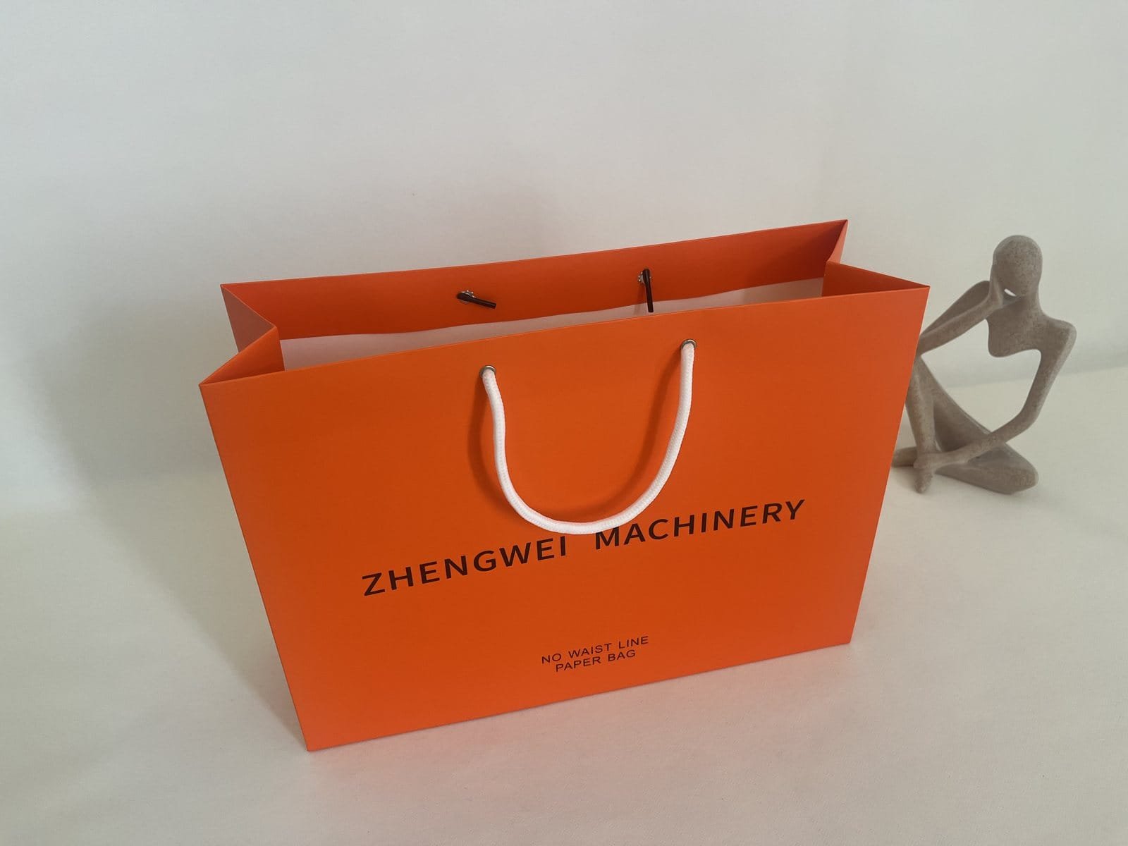 Orange landscape paper bag sample with white round rope handles