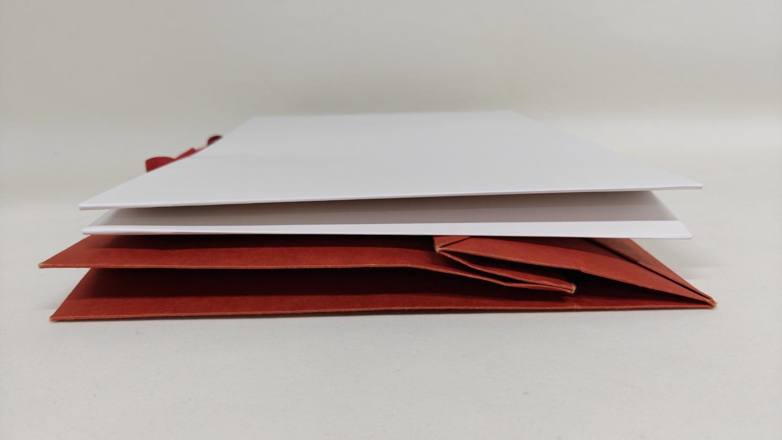 Seamless and traditional paper bags flat folded and stacked side by side