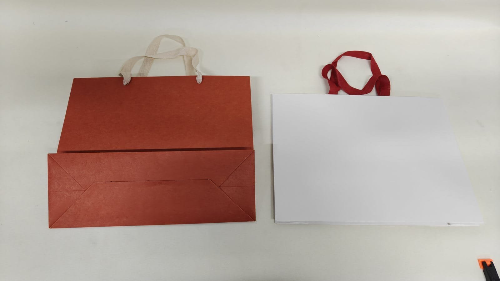 Traditional paper bag beside a seamless paper bag with an uninterrupted front panel