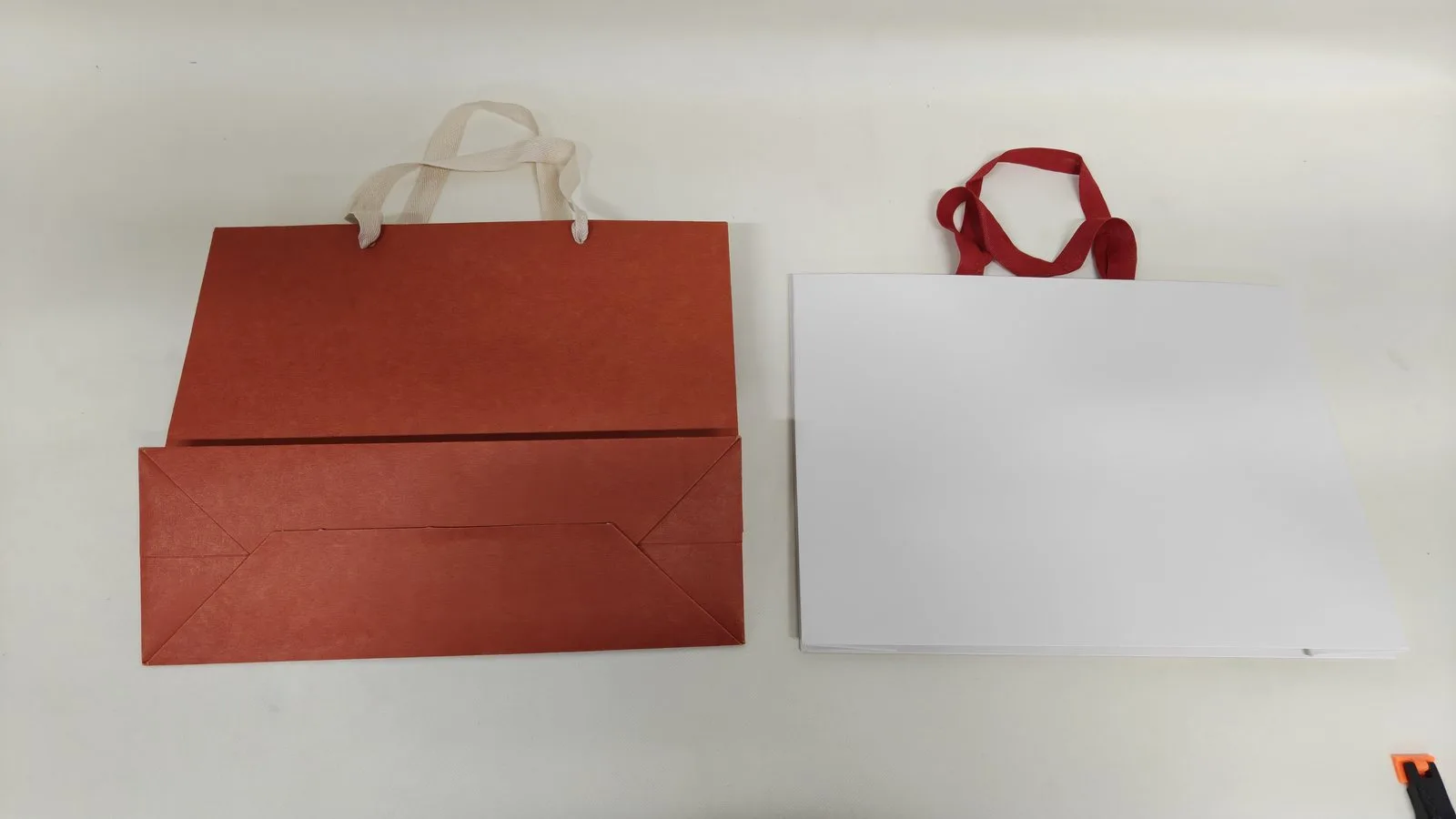 Traditional paper bag beside a seamless paper bag with an uninterrupted front panel